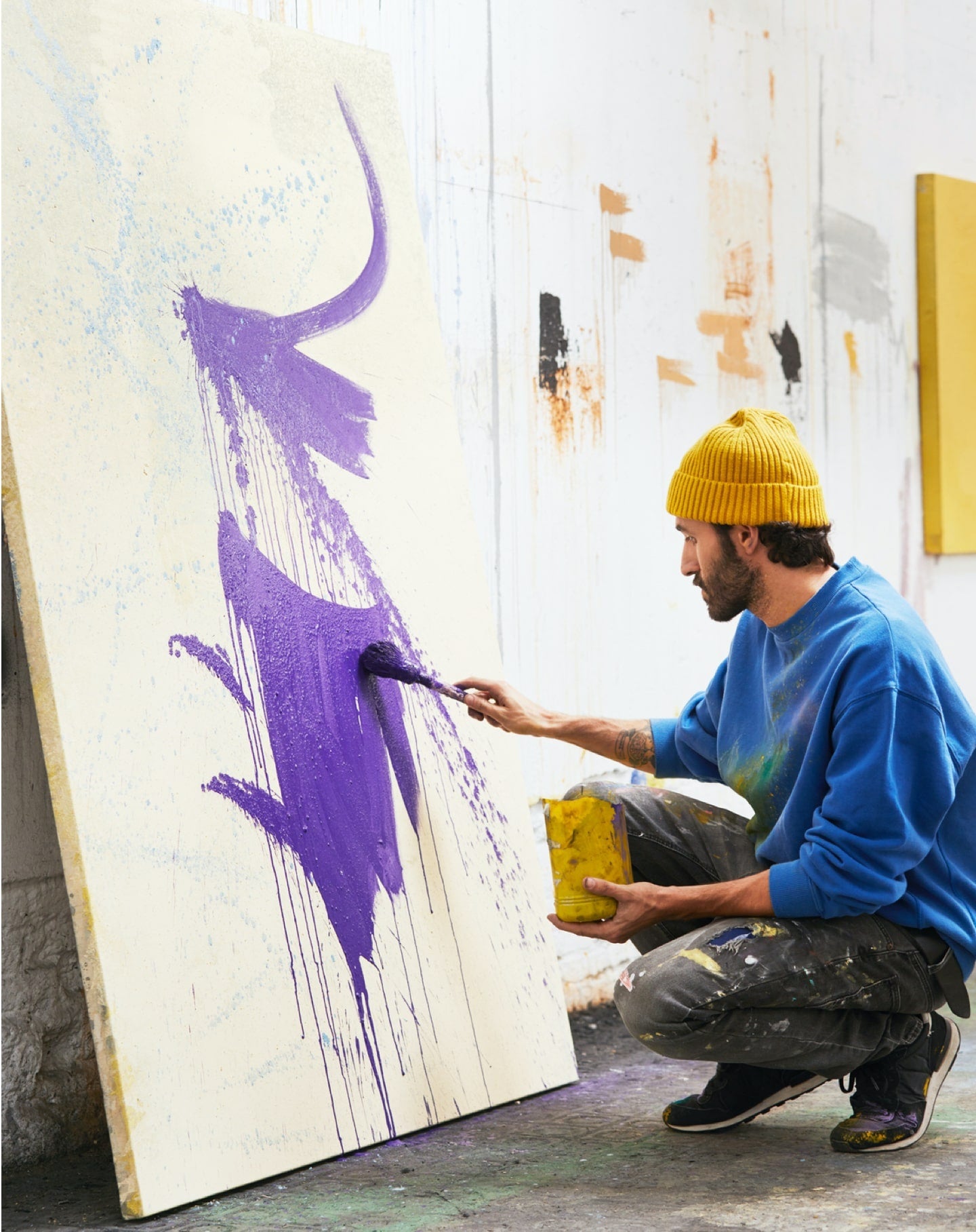Une artiste dans son studio travaille sur une peinture pour son site de peintre